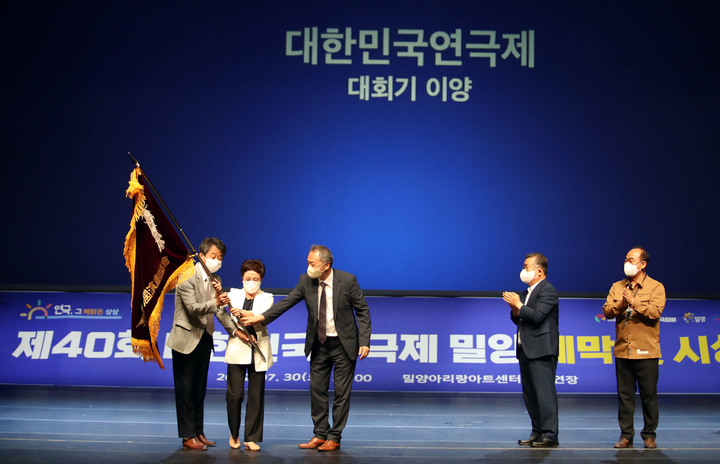 [밀양=뉴시스] 안지율 기자 = 경남 밀양시 아리랑아트센터 대공연장에서 제40회 대한민국연극제 폐막식이 열린 30일 오후 박일호(오른쪽 두 번째) 시장이 내년도 개최예정지인 제주도의 김미영 문화정책과장에게 대회기를 이양하고 있다. (사진=밀양시 제공) 2022.07.31. photo@newsis.com *재판매 및 DB 금지