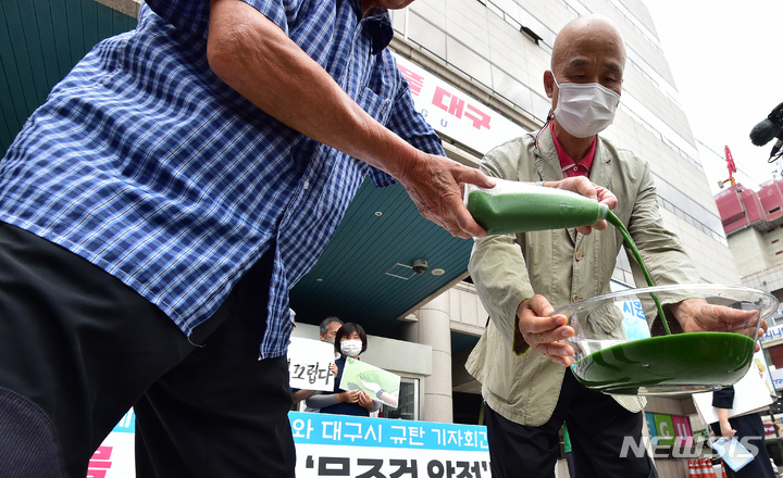 [대구=뉴시스] 이무열 기자 = 1일 오전 대구시청 앞에서 낙동강네트워크 등 시민단체가 대구 수돗물 녹조 독소 검출 파동에 대한 환경부와 대구시 규탄 기자회견에서 낙동강 녹조 수돗물을 따르는 퍼포먼스를 하고 있다. 2022.08.01. lmy@newsis.com
