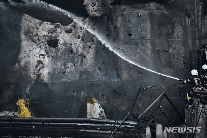 [미콜라이우=AP뉴시스] 2일(현지시간) 우크라이나 미콜라이우에서 국가비상국 소방관들이 전날 밤 러시아군의 야간 포격이 있고 난 뒤 기름 탱크에 물을 뿌리고 있다. 인구 50만 명의 미콜라이우는 우크라이나 군이 탈환을 노리는 러시아 점령지 남부 헤르손과 가장 인접한 곳으로 러시아 군은 지속해서 이곳을 공습하고 있다. 2022.08.03.