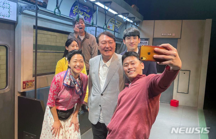 [서울=뉴시스] 윤석열 대통령이 3일 서울 종로구 대학로 한 극장에서 연극 '2호선 세입자'를 관람한 뒤 배우들과 기념촬영을 하고 있다. 윤 대통령은 연극 관람 후 인근 식당에서 배우들과 식사하며 연극계의 어려운 사정에 대해 경청한 뒤 배우들을 격려했다. (사진=대통령실 제공) 2022.08.03. photo@newsis.com
