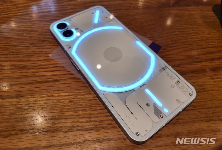 [서울=뉴시스]영국 스타트업 낫싱의 첫 스마트폰 '폰원(phone(1))'. 폰원의 가장 큰 특징인 후면부 '글리프 글라스'에 LED 조명이 켜져 있다. (사진=윤현성 기자)