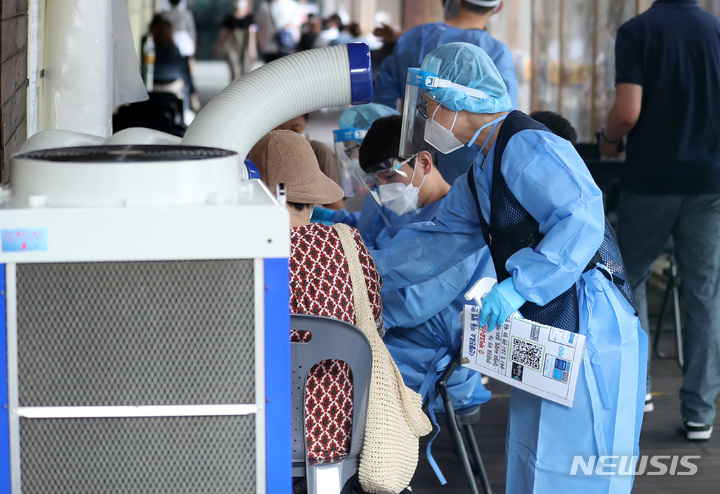 [서울=뉴시스] 이영환 기자 = 4일 오전 서울 송파구보건소 선별진료소를 찾은 시민들이 코로나19 검사를 받기 위해 대기하며 관계자에게 안내를 받고 있다. 2022.08.04. 20hwan@newsis.com