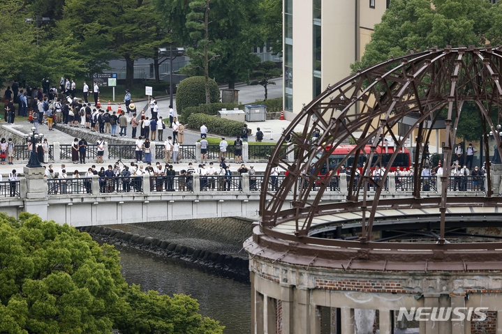 [히로시마=교도·AP/뉴시스]2022년 8월6일 일본 서부 히로시마에서 열린 원폭 투하 77주년 기념식에서 방문객들이 히로시마 평화기념공원에서 원자폭탄이 폭발한 시간인 오전 8시15분에 맞춰 원폭 희생자들을 위한 1분간의 묵념을 하고 있다. 원폭돔이 오른쪽 앞에 보인다. 2023.02.07.