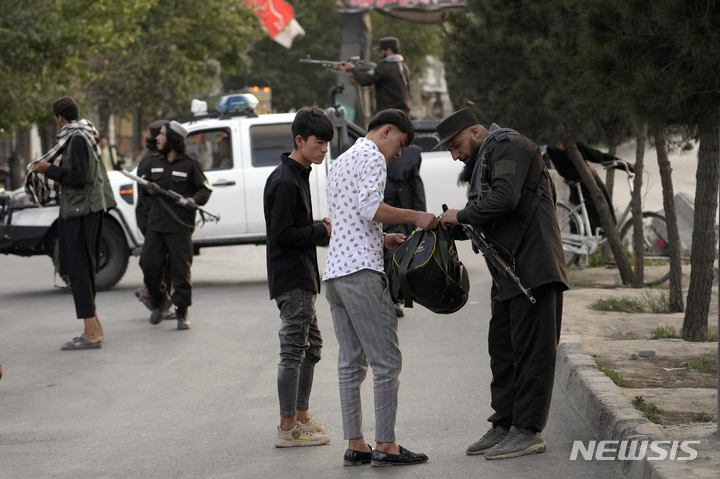 [카불=AP/뉴시스] 7일(현지시간) 아프가니스탄 카불의 시아파 하자라족 거주지인 다시트-에-바르치에서 탈레반 병사가 경비를 서며 행인들을 검문하고 있다. 2022.08.08.
