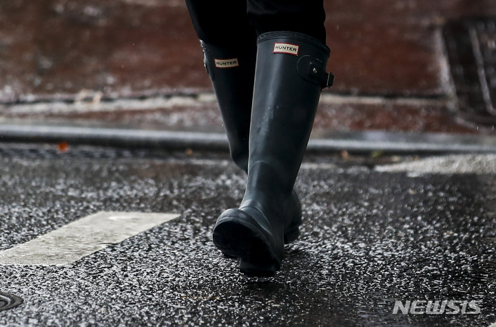 [서울=뉴시스] 정병혁 기자 = 비가 내린 8일 오전 서울 송파구 잠실역 인근에서 장화를 신은 시민이 이동하고 있다. 2022.08.08. jhope@newsis.com