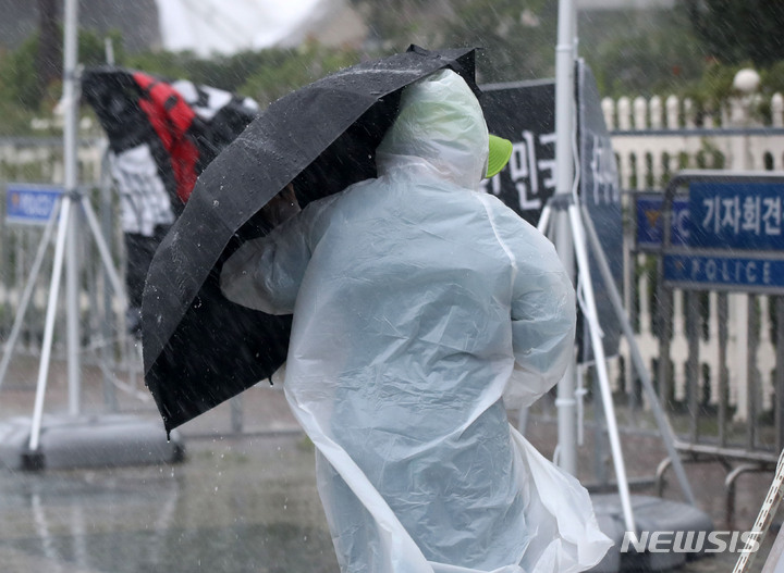 [서울=뉴시스] 고범준 기자 = 서울 등 중부를 중심으로 폭우가 쏟아지는 8일 오후 서울 여의도 국회 정문 앞에서 시민들이 우산을 쓰고 지나가고 있다. 2022.08.08. bjko@newsis.com