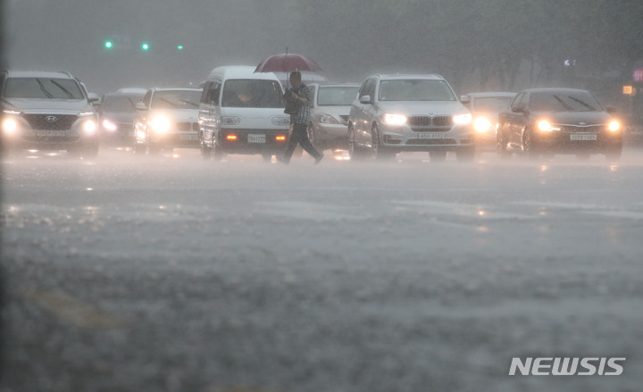 [서울=뉴시스] 권창회 기자 = 비가 내리고 있는 8일 오후 서울 강동구 둔촌역 인근에서 시민들이 우산을 쓰고 이동하고 있다. 2022.08.08. kch0523@newsis.com