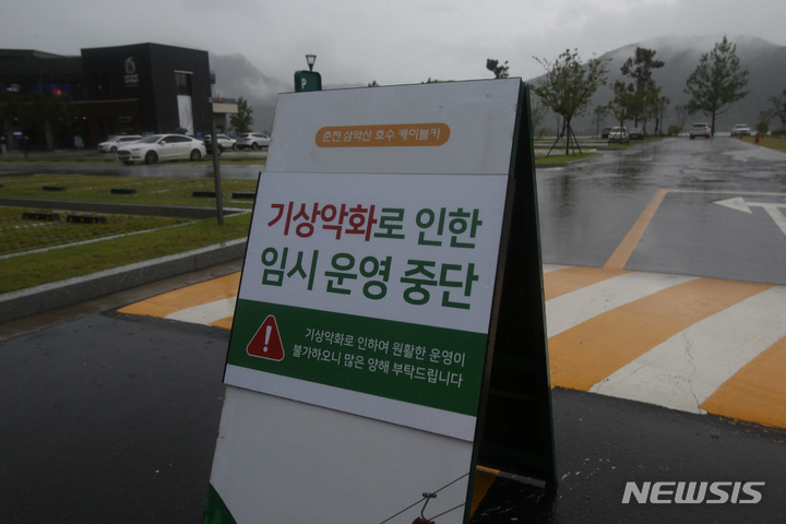 [춘천=뉴시스] 김경목 기자 = 호우특보가 발효 중인 8일 오후 강원 춘천시 삼천동 춘천 삼악산 호수 케이블카 시설 주차장 입구에 낙뢰 사고 예방을 위해 임시 운영을 중단한다는 안내 간판이 세워져 있다. 강원지방기상청에 따르면 철원에는 호우경보가 발효 중이다. 춘천, 화천, 홍천·인제·양구·평창 평지, 횡성, 원주, 중부·북부 산지에는 호우주의보가 내려졌다. 오후 5시에는 영월과 정선 평지, 남부 산지에도 호우주의보가 발효된다. 2022.08.08. photo31@newsis.com