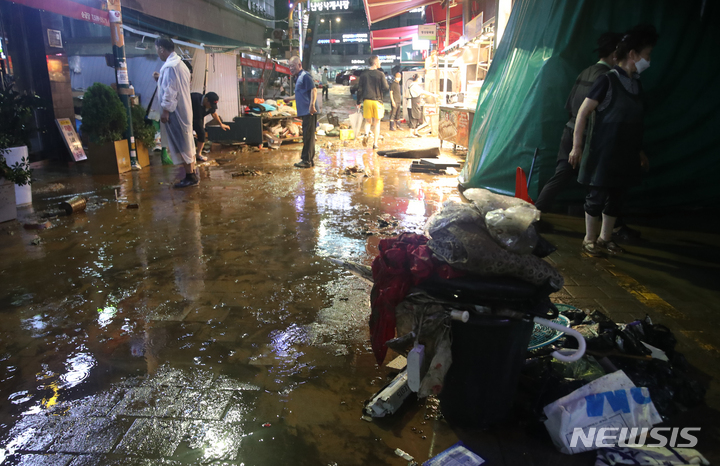 [서울=뉴시스] 고승민 기자 = 서울과 경기북부 등 수도권에 폭우가 내린 9일 새벽 서울 이수역 인근 남성사계시장 일대가 침수돼 물이 빠져나가자 수해를 입은 상인들이 집기 등을 정리하고 있다. 2022.08.09. kkssmm99@newsis.com