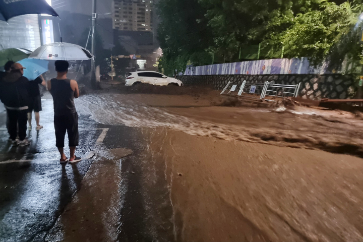 [서울=뉴시스] 고승민 기자 = 집중호우로 서울과 수도권 지역에 피해가 잇따르고 있는 9일 새벽 경기 성남시 중원구의 한 아파트 옆 산자락에서 빗물과 토사가 함께 거세게 쓸려 내려오며 차량을 덮치고 있다. (사진=독자 제공) 2022.08.09. photo@newsis.com *재판매 및 DB 금지