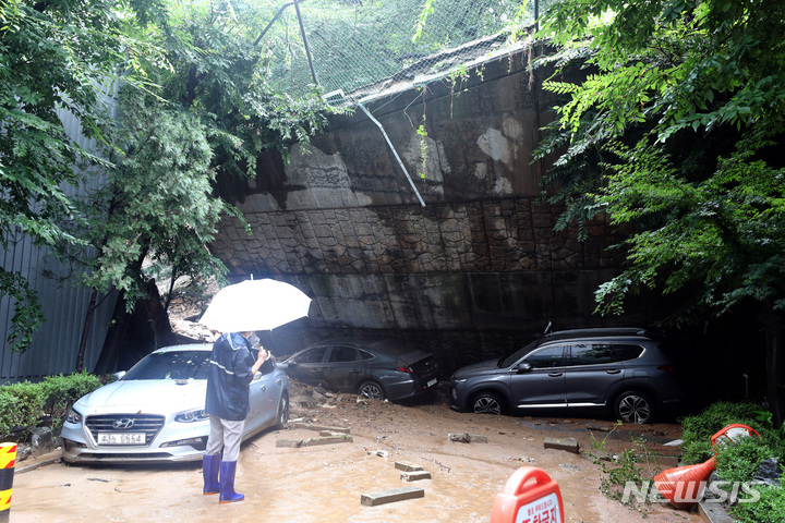 [서울=뉴시스] 이영환 기자 = 폭우로 피해가 발생한 9일 오전 서울 동작구 사당동의 한 아파트 인근 축대가 붕괴 돼 차량이 파손 돼 있다. 2022.08.09. 20hwan@newsis.com