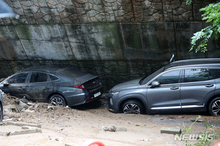 [서울=뉴시스] 이영환 기자 = 폭우로 피해가 발생한 9일 오전 서울 동작구 사당동의 한 아파트 인근 축대가 붕괴 돼 차량이 파손 돼 있다. 2022.08.09. 20hwan@newsis.com