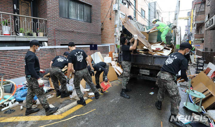 [서울=뉴시스] 권창회 기자 = 폭우가 소강 상태를 보인 10일 오전 서울 관악구 신사시장 인근 빌라촌에서 수방사 35특임대대 소속 장병들이 대민지원을 하고 있다. 2022.08.10. kch0523@newsis.com