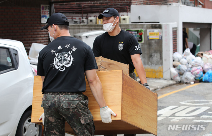 [서울=뉴시스] 권창회 기자 = 폭우가 소강 상태를 보인 10일 오전 서울 관악구 신사시장 인근 빌라촌에서 수방사 35특임대대 소속 장병들이 대민지원을 하고 있다. 2022.08.10. kch0523@newsis.com