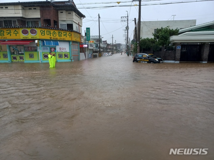 [군산=뉴시스] 윤난슬 기자 = 11일 호우경보가 내려진 전북 군산시 문화동의 한 상가 건물 도로가 물에 잠겨 있다. 이날 군산에는 시간당 70㎜가 넘는 비가 내렸다. 2022.8.11.(사진=독자 제공) yns4656@newsis.com