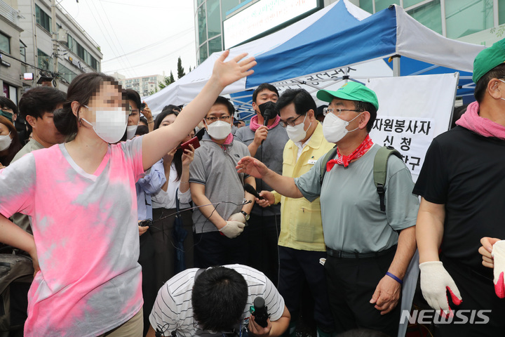 [서울=뉴시스] 국회사진기자단 = 국민의힘 주호영 비상대책위원장 등 지도부가 11일 오전 서울 동작구 사당2동 주민센터 입구에서 수해 복구 봉사활동에 앞서 마이크를 사용해 발언하는 동안, 길을 지나던 한 시민이 국민의힘 지도부를 향해 "길을 막고 지금 뭐하는 거냐"라고 항의하고 있다. 2022.08.11. photo@newsis.com