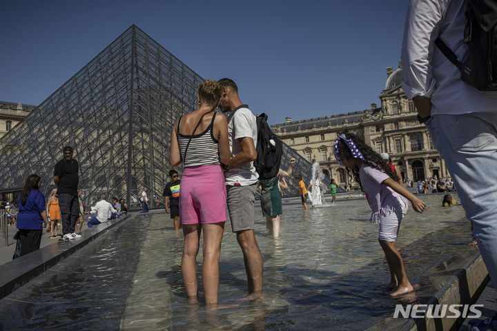 [파리=AP/뉴시스]2022년 8월11일 프랑스 파리의 루브르 박물관 인근 분수대에서 시민들이 더위를 식히고 있다. 프랑스 루부르 박물관 노동자들은 근무 조건 및 기타 불만 사항들로 15일 투표를 통해 파업 돌입을 결정했다. 2025.12.15.