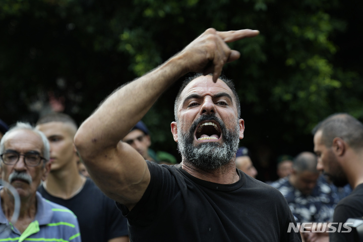 [베이루트(레바논)=AP/뉴시스]경제 위기로 인한 은행의 예금 인출 제한에 분노한 레바논의 바삼 알 세이크 후세인이라는 남성이 11일(현지시간) 베이루트의 한 은행에서 인질극을 벌이며 예금 인출을 요구하는 동안 은행 밖에 모인 군중들이 그를 "영웅"이라고 추켜세우며 지지하는 시위를 벌이고 있다. 2022.8.12