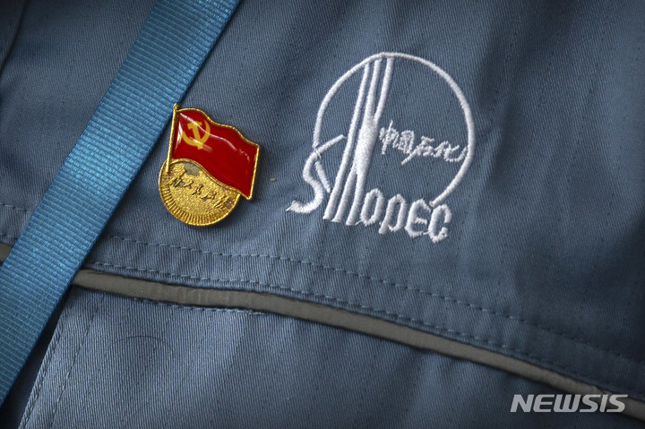 [베이징=AP/뉴시스]지난 2018년 5월25일 베이징 외곽의 중국석유화학(시나펙) 옌산 공장의 한 노동자가 입고 있는 유니폼에 중국 공산당 배지가 꼽혀 있다. 미 규제 당국이 감사 기록을 볼 수 있는지 여부를 둘러싸고 미국과 중국 간에 논쟁이 벌어지는 가운데 중국의 3개 대규모 국영기업이 12일 뉴욕증권거래소(NYSE)에 대한 상장 폐지를 발표했다. 이는 기술과 안보 문제에 대한 마찰로 세계 1, 2위의 경제국인 미국과 중국 간 탈동조화(디커플링) 또는 분리(disengagement) 움직임을 더욱 가속화하고 있음을 보여주는 것이다. 2022.8.12 