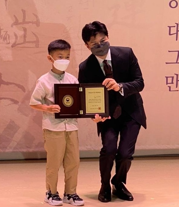 [광주=뉴시스] 이영주 기자 = 11일 대한민국임시정부기념관에서 열린 독립지사 후손 국적증서 수여식에서 우가이 예고르(8)군이 한동훈 법무부장관으로부터 대한민국 국적을 받고 있다. 광주고려인마을 제공 *재판매 및 DB 금지