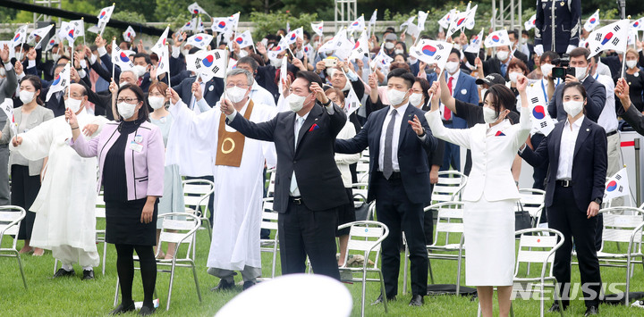 [서울=뉴시스] 홍효식 기자 = 윤석열 대통령과 부인 김건희 여사가 15일 서울 용산 대통령실 잔디마당에서 열린 제77주년 광복절 경축식에서 참석자들과 함께 만세 삼창을 하고 있다. 2022.08.15. yesphoto@newsis.com