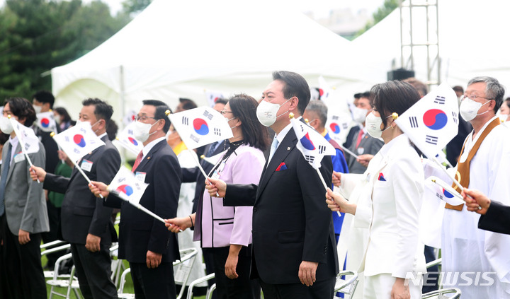 [서울=뉴시스] 홍효식 기자 = 윤석열 대통령과 부인 김건희 여사가 15일 서울 용산 대통령실 잔디마당에서 열린 제77주년 광복절 경축식에서 태극기를 흔들며 광복절 노래를 제창하고 있다. 2022.08.15. yesphoto@newsis.com