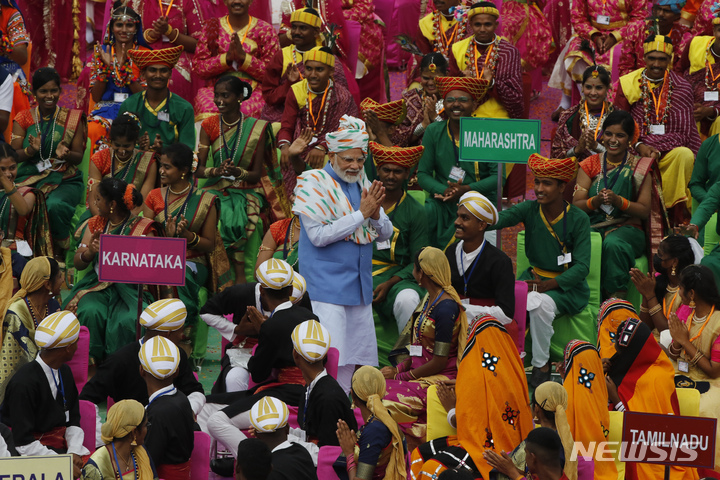 [뉴델리(인도)=AP/뉴시스]나렌드라 모디 인도 총리(사진 가운데)가 15일 인도의 독립기념일에 뉴델리에서 열린 17세기 무굴시대 붉은 요새에서 공연하는 예술가들을 맞이하고 있다. 이날 인도는 영국의 지배로부터 독립한 지 75주년이 된다. 2022.08.15.