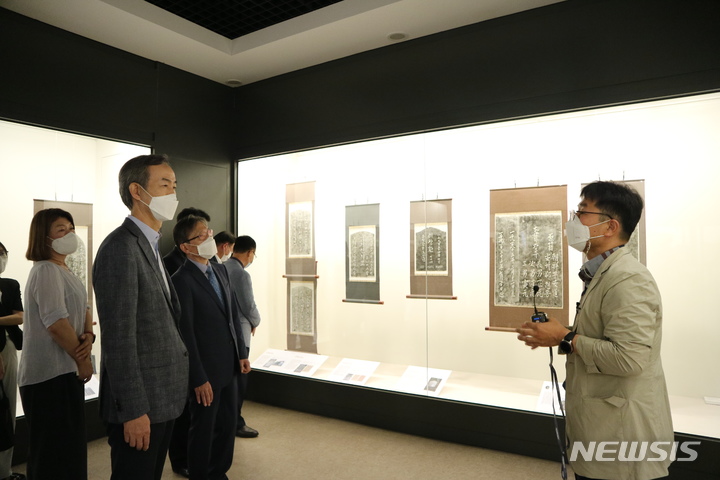 [창원=뉴시스] 홍정명 기자= 이호영 창원대학교 총장 등이 지난 11일 창원대 박물관에서 개막한 창원대학교 박물관-해군사관학교 박물관 연합특별전시회 '잊혀진 이야기, 역사가 되다' 전시 작품에 대한 설명을 듣고 있다.(사진=창원대 제공) 2022.08.17. photo@newsis.com