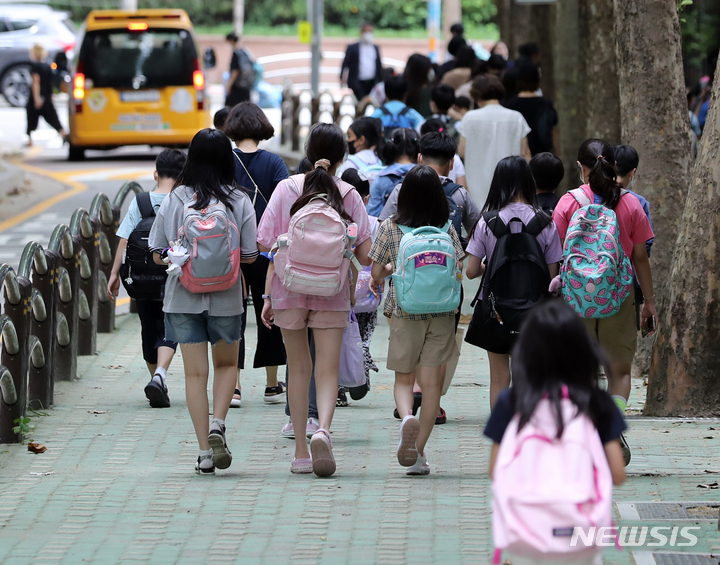 [서울=뉴시스] 김금보 기자 = 코로나19 하루 확진자 수가 126일만에 최다인 18만803명을 기록한 지난 17일 오후 서울 시내 한 초등학교에서 수업을 마친 학생들과 보호자들이 하교하고 있다. 코로나19 재확산 속에 개학을 맞은 학생과 보호자들의 우려가 커지고 있다. 2022.08.22. kgb@newsis.com