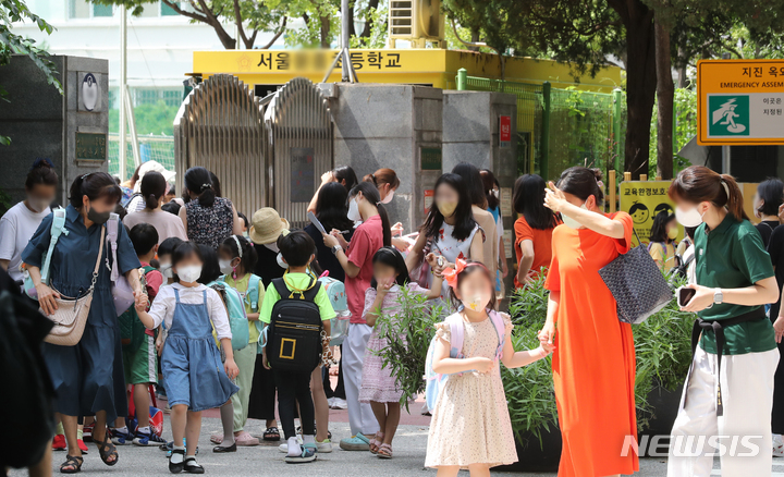 [서울=뉴시스] 김금보 기자 = 코로나19 하루 확진자 수가 126일만에 최다인 18만803명을 기록한 17일 오후 서울 시내 한 초등학교에서 수업을 마친 학생들과 보호자들이 하교하고 있다. 코로나19 재확산 속에 개학을 맞은 학생과 보호자들의 우려가 커지고 있다. 2022.08.17. kgb@newsis.com