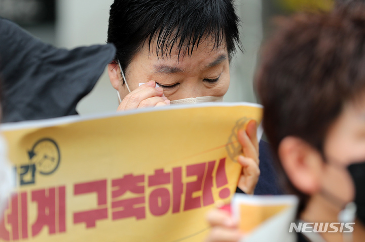 [서울=뉴시스] 백동현 기자 = 장애인부모연대 한 회원이 지난해 8월18일 오전 서울 중구 서울시의회 앞에서 폭우참사로 희생된 발달장애인과 그 가족에 대한 추모 기자회견에서 눈물을 닦고 있다. 2022.08.18. livertrent@newsis.com