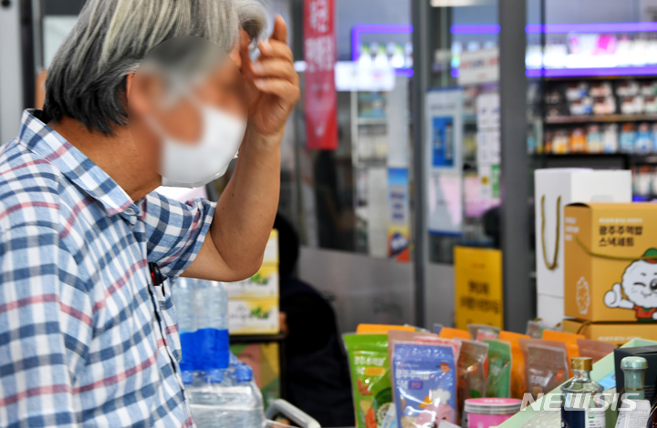 [광주=뉴시스]  20일 오전 광주 광산구 광주송정역 대합실 편의점에서 열차를 기다리던 한 승객이 진열된 지역특산품들을 바라보고 있다. 2022.08.20. leeyj2578@newsis.com