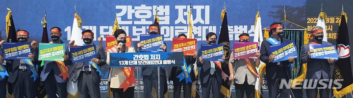 [서울=뉴시스] 고범준 기자 = 간호법 저지 13개 단체 보건의료연대 출범식이 열린 23일 서울 여의도 국회 앞에서 참석한 보건의료연대 회원들이 손 피켓을 들고 구호를 외치고 있다. 2022.08.23. bjko@newsis.com