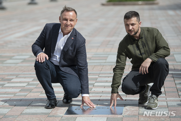 [키이우=AP/뉴시스] 볼로디미르 젤렌스키(오른쪽) 우크라이나 대통령과 안제이 두다 폴란드 대통령이 23일(현지시간) 키이우에서 열린 '용자의 거리' (Walk of the brave) 개막식에 참석해 두다 대통령의 이름이 적힌 판 위에서 기념 촬영을 하고 있다. '용자의 거리'는 러시아의 우크라이나 침공에 맞서 싸우는 데 도움을 준 사람들의 이름을 새겨 기념하는 것으로 두다 대통령이 첫 이름을 올렸다. 2022.08.24.