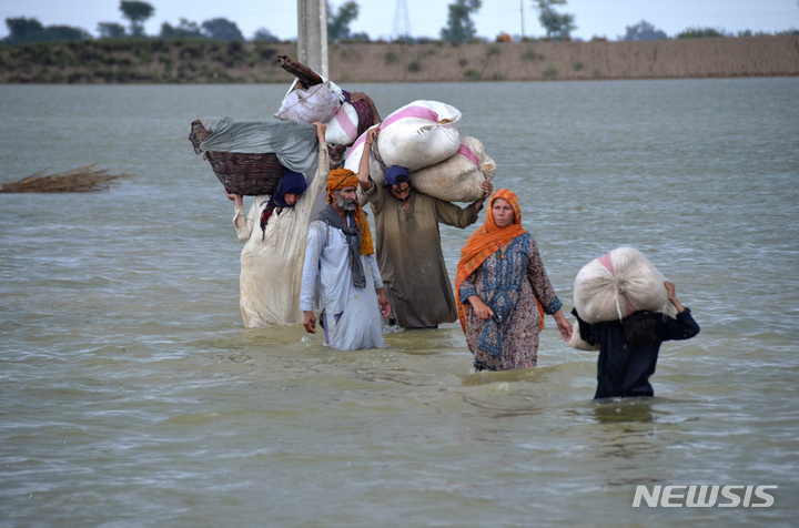 [자히드 후세인=AP/뉴시스] 24일 파키스탄 남서부 발루치스탄 주의 자프라바드에서 실향민 가족이 폭우로 침수된 지역을 헤매고 있다. 2022.08.26. 