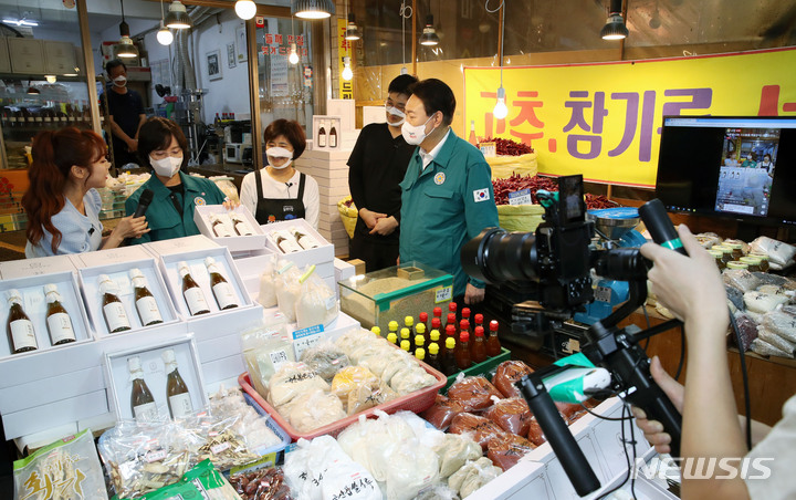 [서울=뉴시스] 전신 기자 = 윤석열 대통령이 25일 서울 강동구 암사종합시장을 방문해 라이브 커머스 방송을 참관하고 있다. 2022.08.25. photo1006@newsis.com