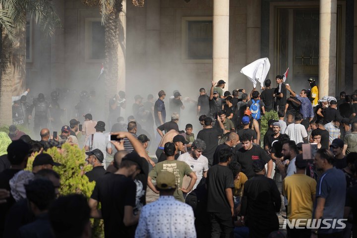 [바그다드=AP/뉴시스] 29일(현지시간) 이라크 바그다드 시내 그린존에 있는 정부청사에 시아파 성직자 겸 정치인 무크타다 알 사드르 추종자들이 몰려들어 시위하고 있다. 시위대는 알 사드르가 정계 은퇴를 선언하자 이에 반발하며 경쟁자의 정부 구성을 막기 위해 정부청사로 몰려들었다. 2022.08.30.