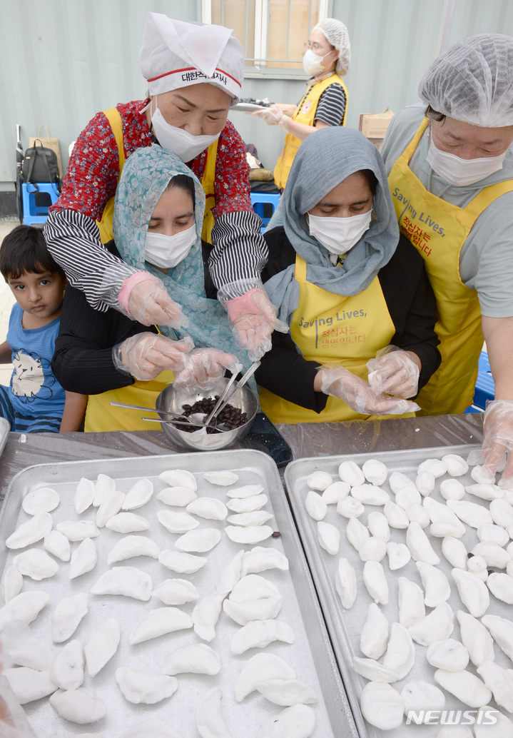 [울산=뉴시스] 배병수 기자 = 30일 오전 울산 동구 현대중공업 중앙아파트 입구에서 열린 추석맞이 송편만들기 행사에서 대한적십자 봉사자와 아프가니스탄 특별기여자 가족들이 송편을 만들고 있다. 2022.08.30. bbs@newsis.com