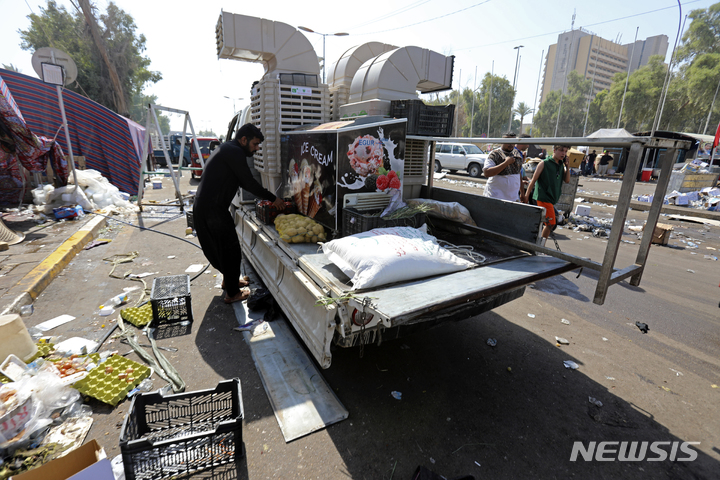 [바그다드=AP/뉴시스] 30일(현지시간) 이라크 바그다드의 그린존에 있는 의회 건물 밖에서 시아파 성직자 겸 정치인 무크타다 알 사드르의 지지자들이 시위 현장을 떠나면서 기물을 정리하고 있다. 앞서 정계 은퇴를 선언한 알 사드르는 그의 지지자들에게 정부 청사에서 철수할 것을 촉구했다. 2022.08.31.