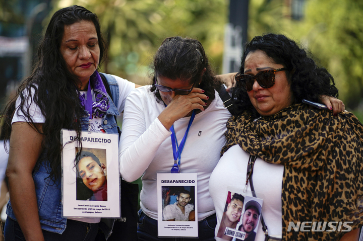[ 멕시코시티= AP/뉴시스] 멕시코의 엄마들이 30일(현지시간) 국제 실종자의 날을 맞아 그 동안 사라진 아들 딸과 가족의 사진을 목에 걸고 행진하며 울고 있다. 