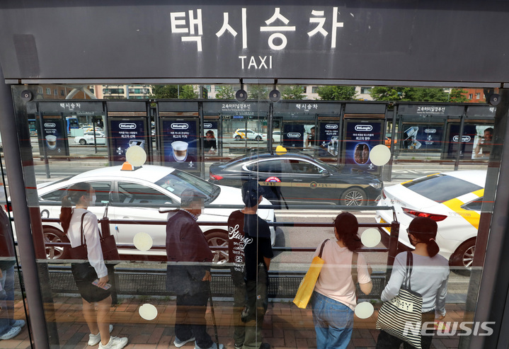 [서울=뉴시스] 이영환 기자 = 2일 오후 서울 시내의 한 택시 승강장에서 시민들이 택시 탑승을 기다리고 있다. 서울시가 지난 1일 심야 택시 승차난 해소를 위한 요금안을 마련하고 서울시의회에 의견청취안을 제출했다. 요금안에 따르면 요금안에 따르면 택시 기본요금은 기존 3800원에서 4800원으로 1000원 인상된다. 기본거리는 현행 2㎞에서 1.6㎞로 줄어들고, 거리요금 기준은 132m당 100원에서 131m당 100원으로 1m 축소된다. 시간요금도 31초당 100원에서 30초당 100원으로 조정된다. 심야 할증시간은 당초 자정부터 익일 오전 4시까지였으나 밤 10시부터 익일 오전 4시까지로 2시간 늘어난다. 20%로 일률 적용하던 심야 할증률도 20~40%로 뛴다. 밤 10시~11시, 익일 새벽 2시~4시까지 20%의 할증률을 적용하고, 밤 11시부터 익일 새벽 2시 사이에는 40%를 적용하는 식이다. 시계외 할증은 기존대로 20%를 유지할 예정이다. 우선 오는 5일 공청회를 열어 택시 업계, 전문가, 시민 의견 등을 토대로 인상안에 대해 논의할 예정이다. 2022.09.02. 20hwan@newsis.com