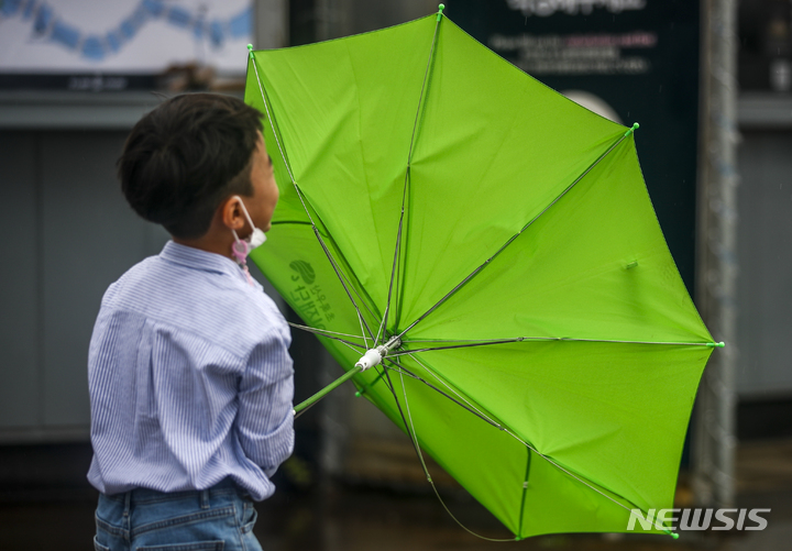 [서울=뉴시스] 정병혁 기자 = 태풍 '힌남노'가 북상중인 4일 오후 서울 영등포구 여의도한강공원에서 한 시민의 우산이 바람에 뒤집히고 있다. 2022.09.04. jhope@newsis.com