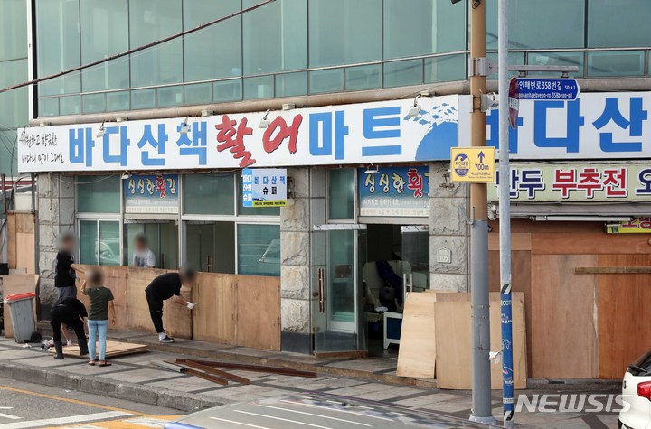 [부산=뉴시스] 하경민 기자 = 제11호 태풍 '힌남노'가 북상 중인 4일 오후 부산 수영구 민락수변공원 앞 상가의 상인들이 폭풍해일에 대비한 차수벽을 설치하고 있다. 2022.09.04. yulnetphoto@newsis.com