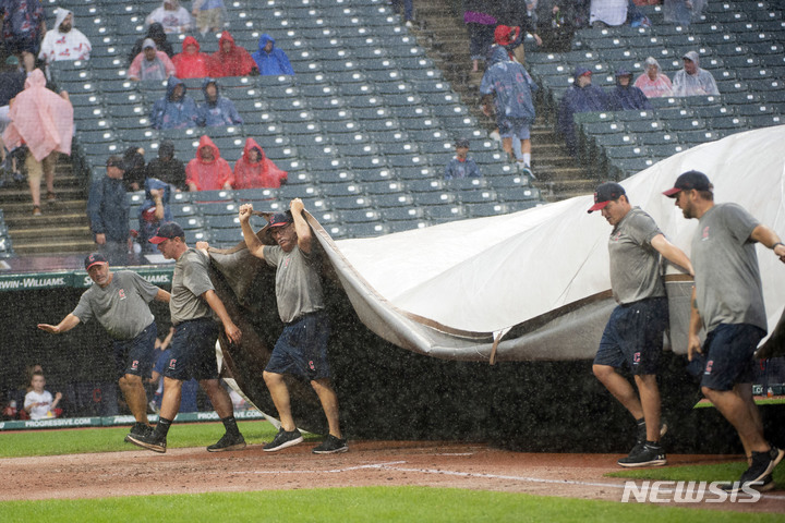 [클리블랜드=AP/뉴시스] 방수포 덮는 클리블랜드 가디언스 스태프. 2022.09.04
