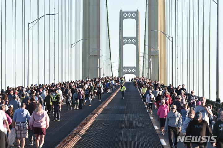 [매키노=AP/뉴시스] 제64회 노동절인 5일(현지시간) 미 미시간주 매키노에서 시민들이 미시간주 매키낙 브리지를 걷고 있다. 보행을 허용하는 유일한 날인 이날 수천 명의 시민이 약 8㎞에 달하는 구간을 건너거나 왕복했다. 노동절을 맞아 이 다리는 오전 6시30분부터 정오까지 비상 상황을 제외하고는 차량 통행이 금지됐다. 2022.09.06.