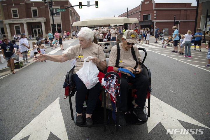 [데니 시몬스=AP/뉴시스] 5일(현지시간) 분빌에서 열린 제136회 노동절 퍼레이드에서 골프 카트를 탄 짐 후치크래프트(Jim Hutchcraft)가 <font _mstmutation="1" _msthash="178997" _msttexthash="4619222205">미국 연합 광산 노동자 1907 소속이었던 베티 메저(Betty Metzger)와 골프 카트에 탑승해 사탕을 던지고 있다. 2022.09.06.</font>