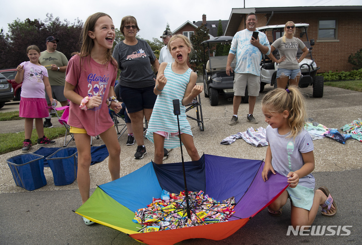 [분빌=AP/뉴시스] 노동절인 5일(현지시간) 미 인디애나주 분빌에서 어린이들이 제136회 연례 노동절 협회 퍼레이드 중 우산에 사탕을 모으고 있다. 이들은 사탕을 던지며 지나가는 퍼레이드 행렬을 향해 구호와 환호를 보내며 그들의 우산에 사탕을 명중하도록 유도했다. 2022.09.06.