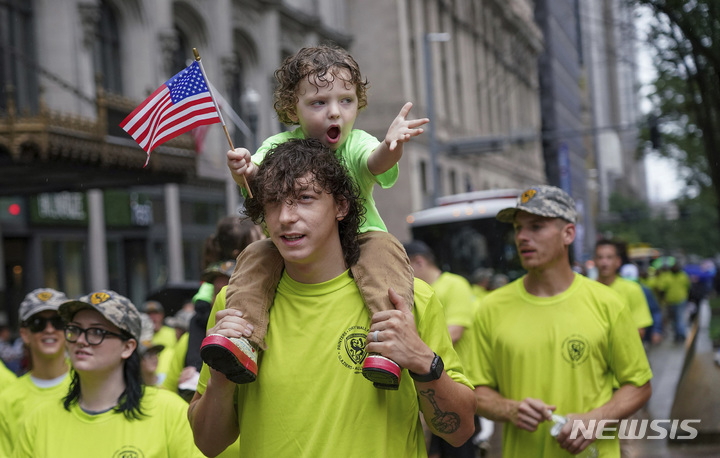 [스티브 밀론=AP/뉴시스] 웨일론 벤더(Waylon Bender)가  5일(현지시간) 미국 피츠버그 시내에서 열린 노동절 퍼레이드에 참석해 그랜트 거리를 따라 행진하며 아빠 벤자민 벤더(Benjamin Bender)의 어깨에서 거친 지지를 표하고 있다. 벤자민 벤더는 Glaziers Local 751(건설회사)의 회원이다. 2022.09.06. 