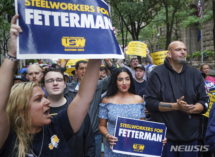 [스티브 밀론=AP/뉴시스] 5일(현지시간) 미국 피츠버그 시내에서 열린 노동절 퍼레이드에서 지지자들이 존 페터먼 (오른쪽) 펜실베니아 민주당 중위 주지사를 둘러싸고 있다. 2022.09.06.