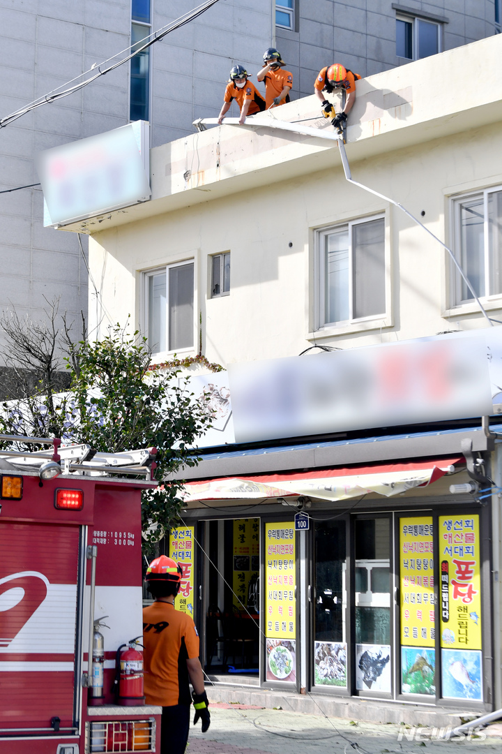 [여수=뉴시스] 이영주 기자 = 제11호 태풍 '힌남노'가 물러난 11일 오전 전남 여수시 수정동 한 상가에서 소방 당국이 떨어진 간판을 제거하고 있다. 2022.09.06. leeyj2578@newsis.com